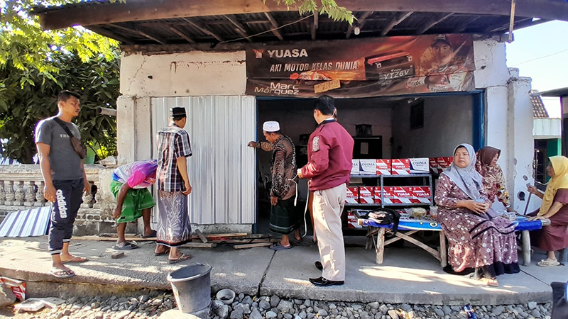 JADI TONTONAN: Sejumlah warga melihat toko aki milik Suryanto di pinggir Jalan Raya Dusun Barat Kebun, Desa Wringinanom, Kecamatan Panarukan, Situbondo, Selasa (25/6).
