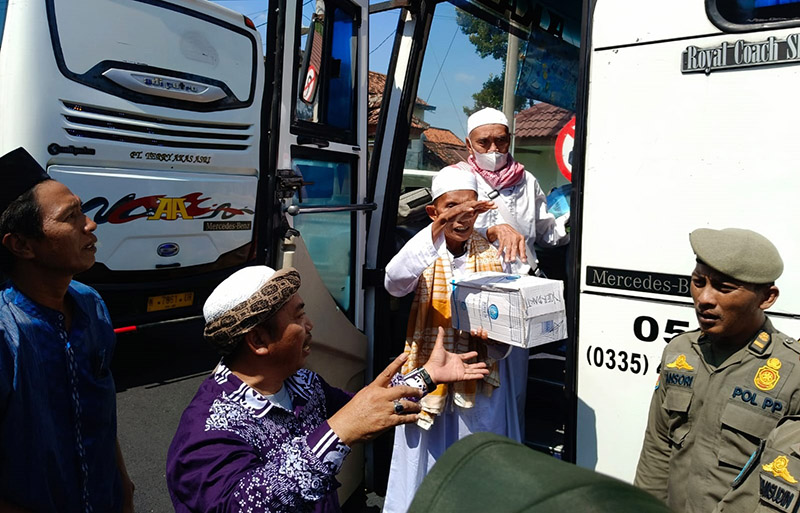 TERHARU: Jamaah haji kloter 55 turun dari bus di Alun-alun Situbondo disambut pelukan hangat keluarganya, Minggu (7/7).