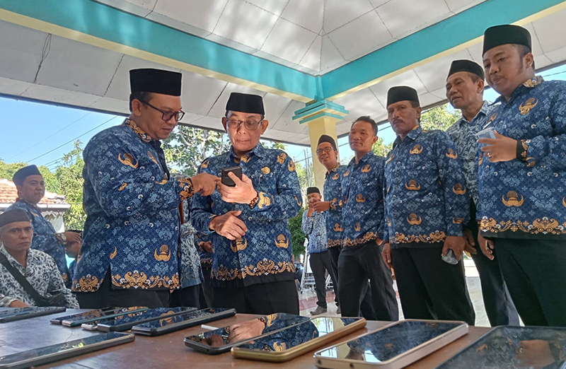 SIDAK: Camat Bungatan Yogie Kripsian Sah mengecek HP milik kades di kantor Kecamatan Bungatan, Rabu (17/7).