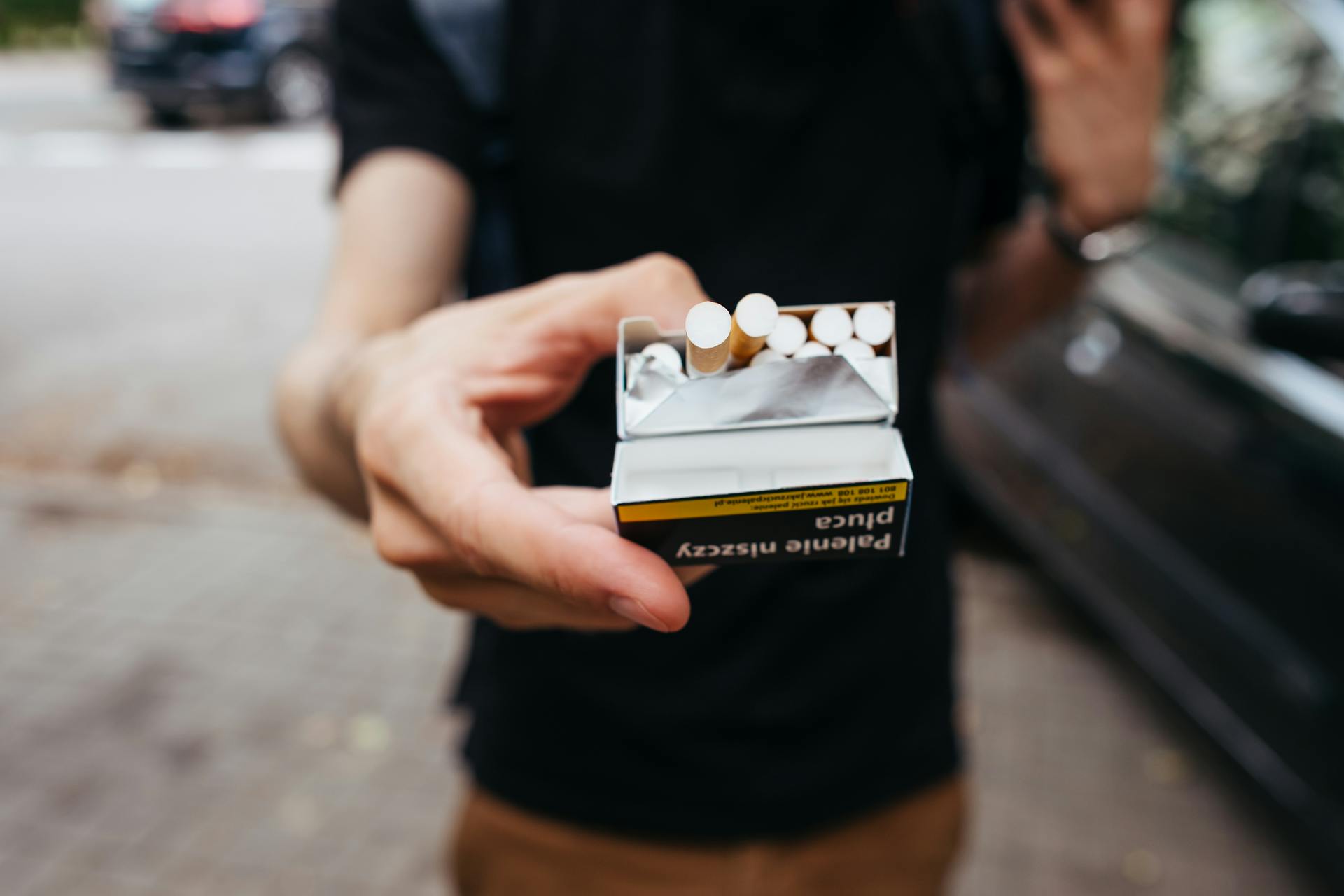 Ilustrasi seorang pria menawarkan rokok.