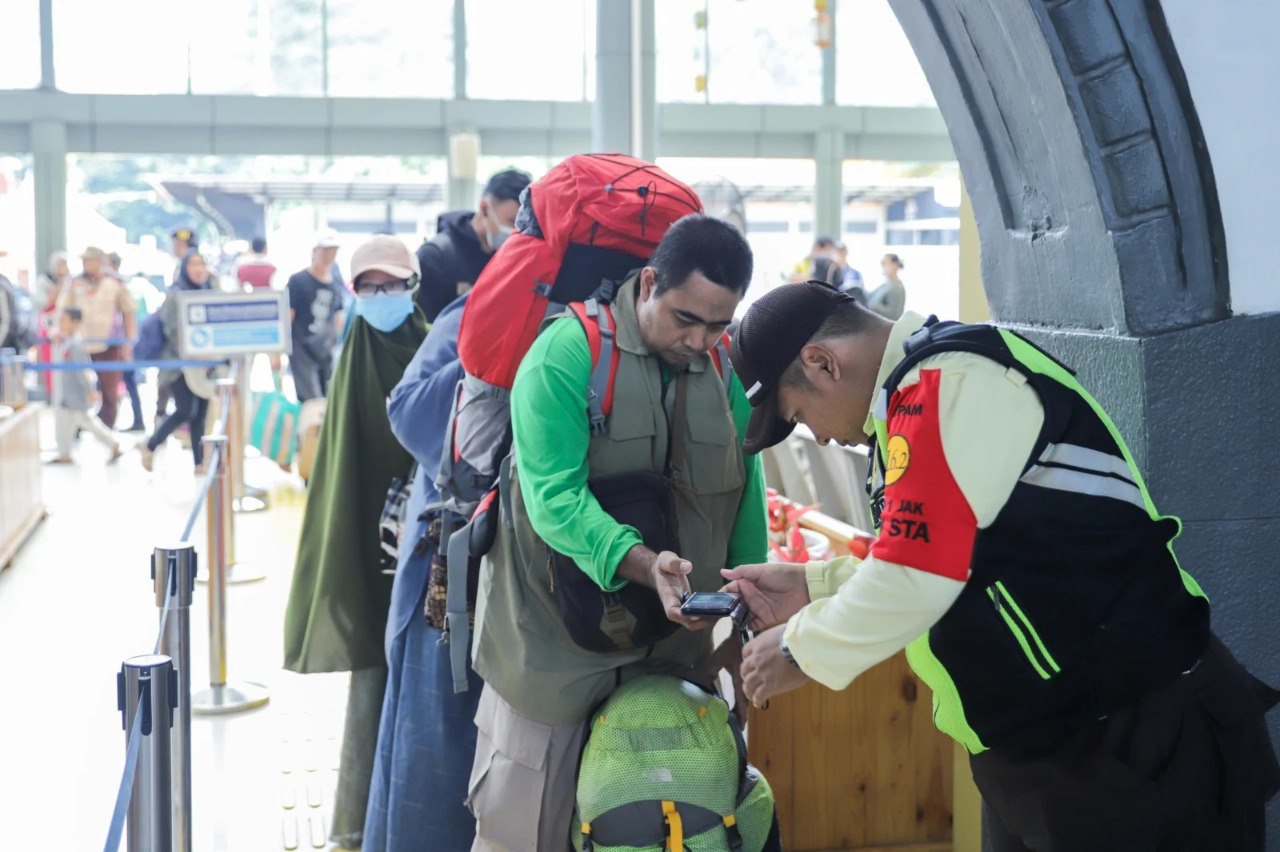 Petugas memeriksa boarding pass penumpang sebelum memasuki area peron.