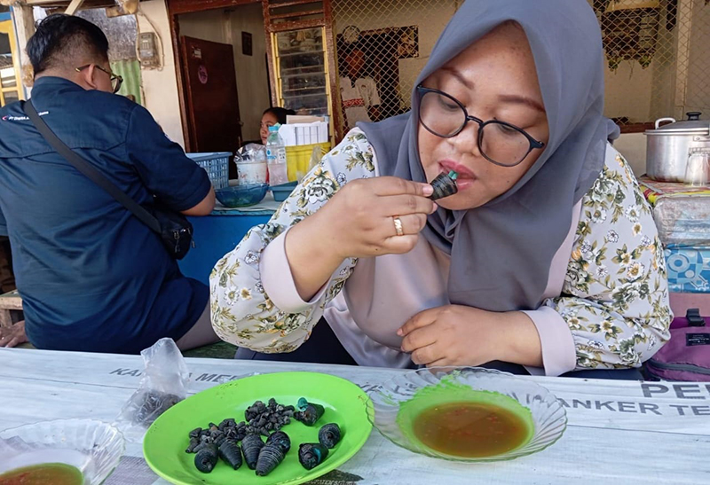 RUJAK LANGKA: Via, 26, warga Desa Sumberkolak, Kecamatan Panarukan, mencicipi rujak concong di warung milik Misyani, Desa Kelensari, Kecamatan Panarukan, Situbondo.