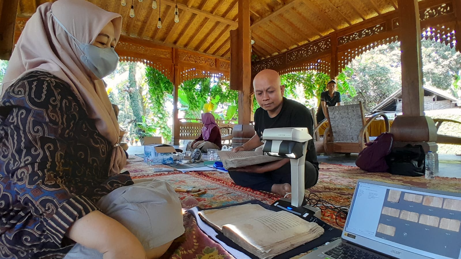 DIARSIPKAN: Karyawan Dinas Perpustakaan dan Kearsipan Situbondo, melakukan digitalisasi aksara kuno di pendopo Murtajaya, Desa Juglangan, Kecamatan Panji, Kamis (8/8).