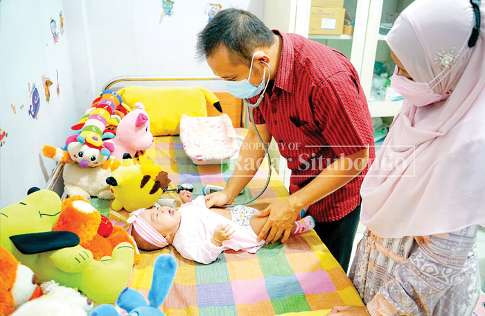POLI ANAK: Dokter spesialis anak, dr. Erfan Hartano, Sp.An memeriksa kondisi balita di Rumah Sakit Mitra Sehat, Desa Curah Jeru, Kecamatan Panji.