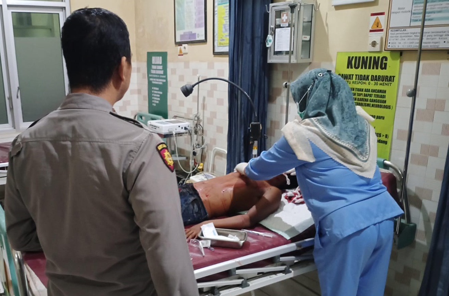 KORBAN PEMBACOKAN: Anggota Polres Situbondo meninjau korban pembacokan Tarto Prayogi, 31, di Puskesmas Bungatan, Senin malam (23/9).