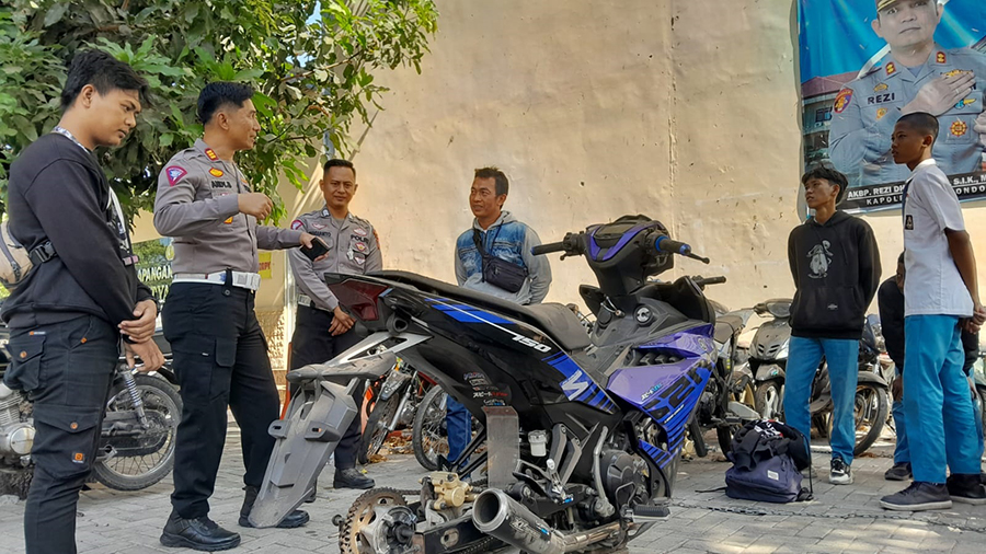 BERI ARAHAN: Kasat Lantas AKP Andy Bakhtera Indera Jaya (dua dari kiri) memberi arahan kepada pelaku balapan liar di halaman belakang Mapolres Situbondo, Senin (7/10).