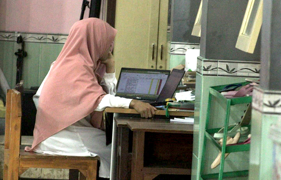 MENGAJAR: Seorang guru di salah satu sekolah sibuk dengan laptopnya di dalam ruang kelas, Rabu (16/10). Mereka memiliki peluang mendaftar dan lolos seleksi PPPK.
