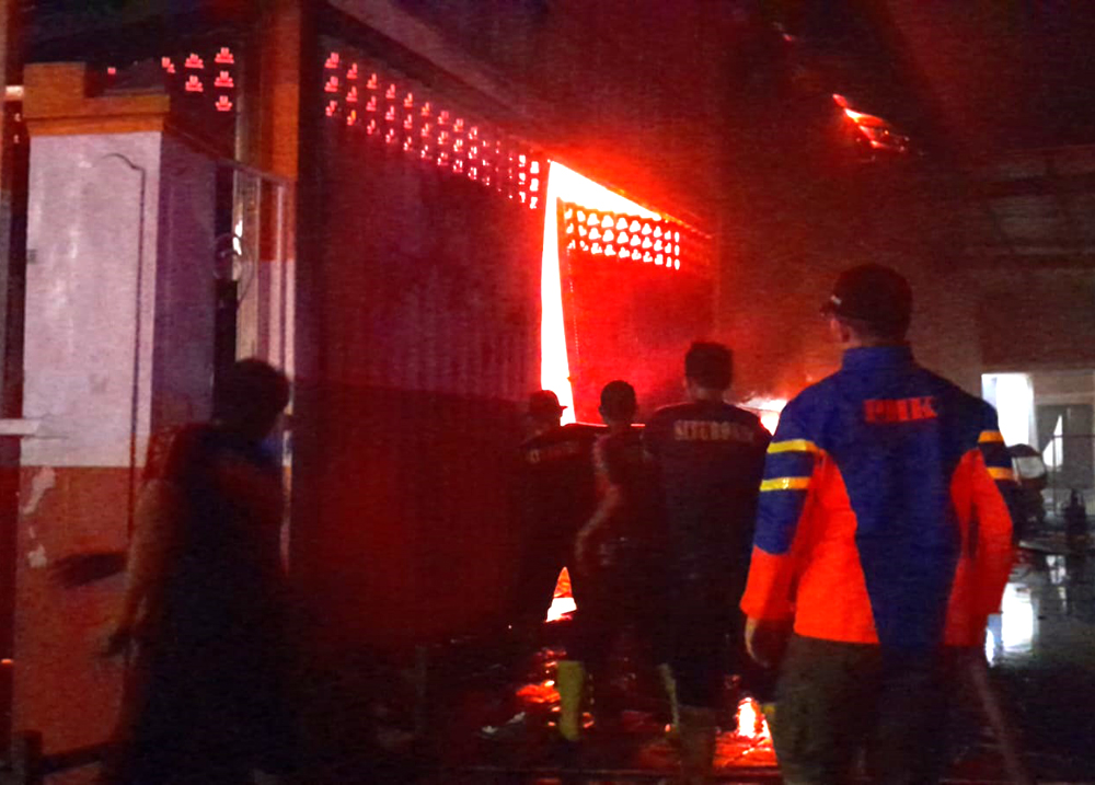 BIKIN PANIK: Petugas Damkar Situbondo, berupaya memadamkan kobaran api dalam Bengkel Mobil Golden Motor, di Kelurahan Mimbaan, Kecamatan Panji, Rabu malam (16/10).