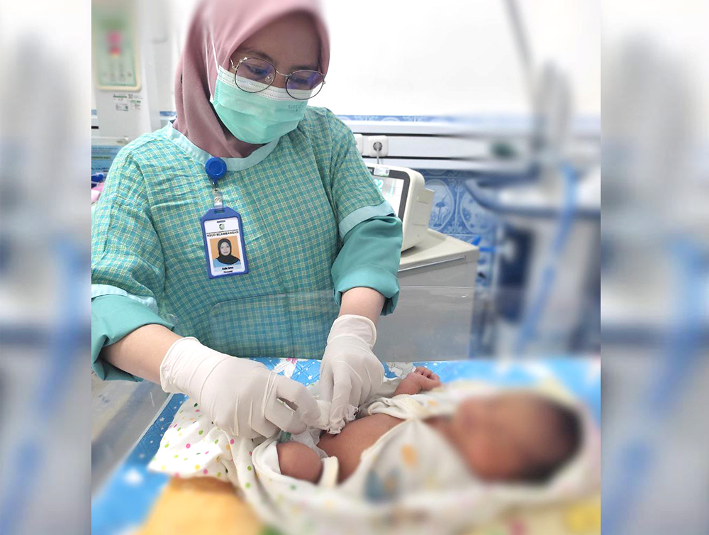 TELATEN: Perawat melakukan perawatan tali pusat bayi di RSUD Blambangan Banyuwangi.