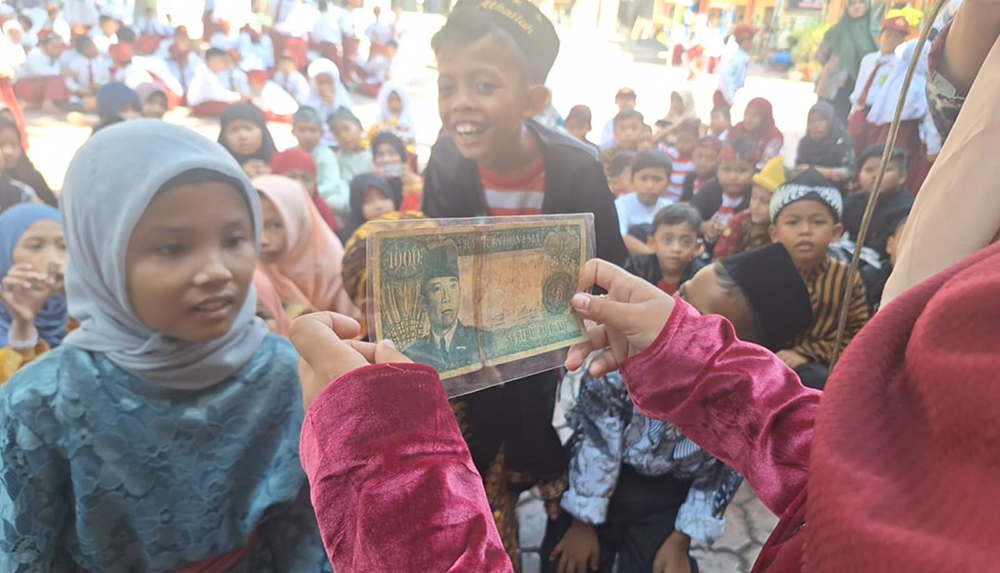 KENANG SEJARAH: Ratusan siswa melihat uang kuno di halaman Sekolah Dasar Islam Nurul Ansor  Terpadu (SDIT) Nurul Anshor, Kelurahan Mimbaan, Kecamatan Kota, Selasa (29/10).