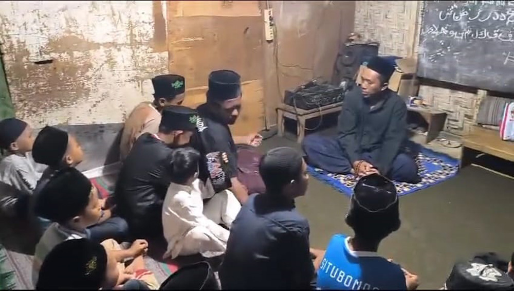 MENGAJAR: Baihaki, 50, warga Dusun Kota Timur, Desa /Kecamatan Besuki, mengajar puluhan santri di amperan rumahnya, Selasa (19/11).