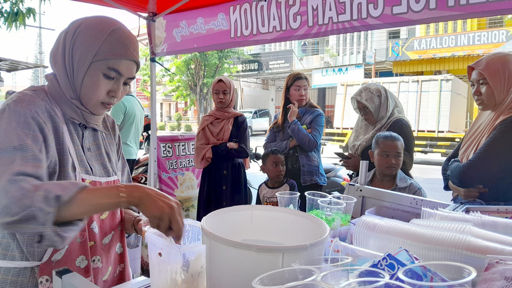 Elisa melayani pembeli di pinggir Jalan Raya, Kenanga, Kelurahan Patokan, Kecmatan/Kota Situbondo, Rabu (20/11).