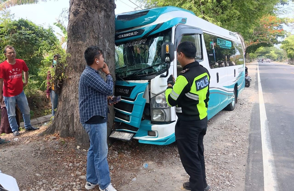 HANTAM POHON: Anggota Kanitlaka Polres Situbondo melihat microbus bernopol P 7603 EA di pinggir Jalan Raya, Desa/Kecamatan Banyuputih, Minggu (24/11) pukul 8.30.