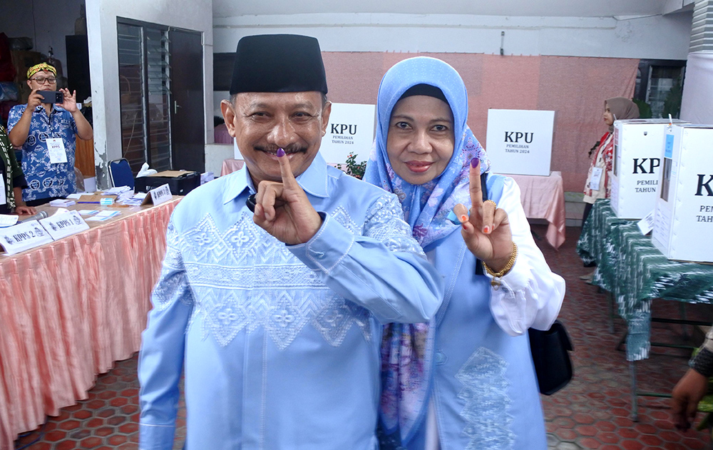 Cabup Karna Suswandi bersama istri Hj. Juma&rsquo;ati Karna Suswandi menunjukkan surat suara yang sudah di coblos di TPS 19, Kelurahan Dawuhan, Kecamatan Kota, Rabu (27/11).