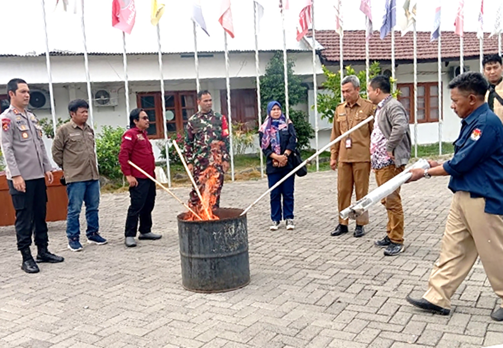 SINERGI: KPU bersama Kapolres, Dansim dan Bawaslu membakar surat suara rusak di dalam tong besar di halaman kantor KPU Situbondo, Selasa (26/11).