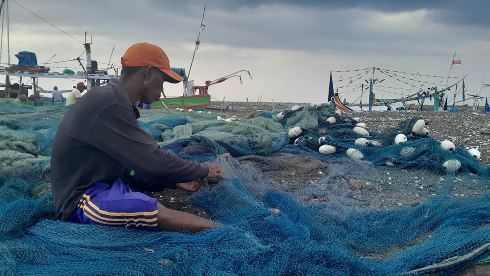TAK MELAUT: Sejumlah nelayan di Pelabuhan Panarukan memperbaiki jaringnya, Jumat (27/12).