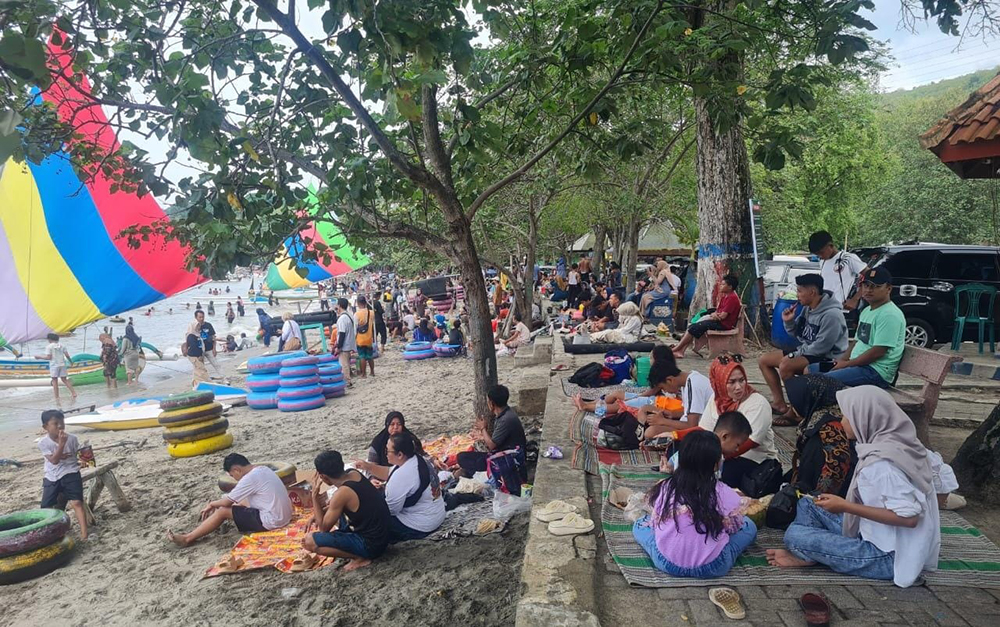 SUASANA PANTAI: Puluhan pengunjung duduk santai di pinggir Pantai Wisata Pasir Putih Situbondo, Senin (30/12).