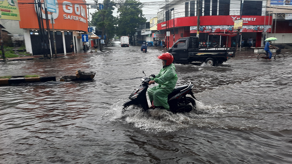 TERGENANG: Pemotor melintas di Jalan Raya Basuki Rahmat Situbondo, Minggu(5/12).