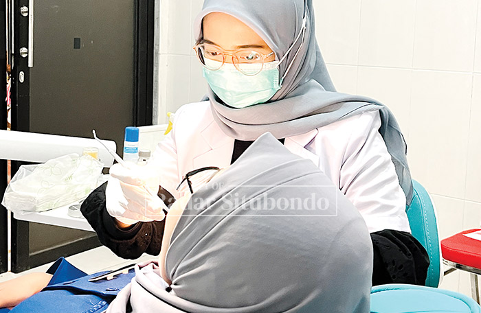 PROFESIONAL: Seorang dokter gigi melayani pasien di Rumah Sakit Mitra Sehat di Desa Curah Jeru, Kecamatan Panji.