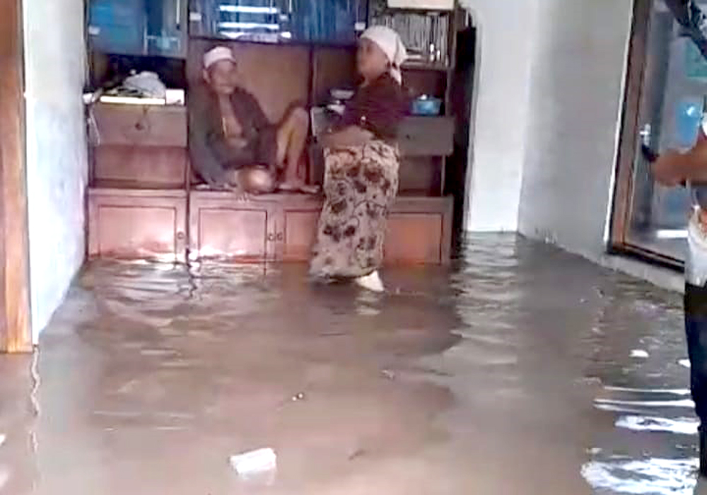 KEBANJIRAN:Seorang kakek di Desa Sumberwaru, lecamatan Banyuputih, naik ke lemari hindari genangan air, Kamis (23/1).