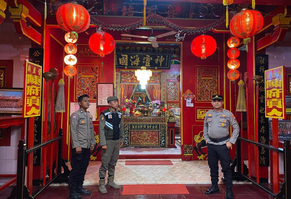 ANTISIPASI: Anggota Polsek Besuki melakukan penjagaan di Kelenteng Poo Tong Biaw, Jalan Teratai, Dusun Pecinan, Desa Besuki, Kecamatan Besuki, Rabu malam (28/1).