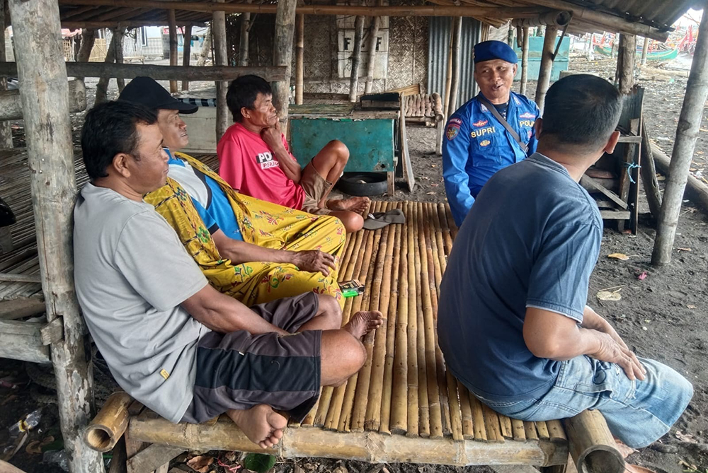 CURHAT POLISI: Anggota Satpolairud Polres Situbondo mendengarkan curhatan nelayan di pinggir pantai Pelabuhan Kalbut, Kecamatan Mangaran, Jumat (31/1).