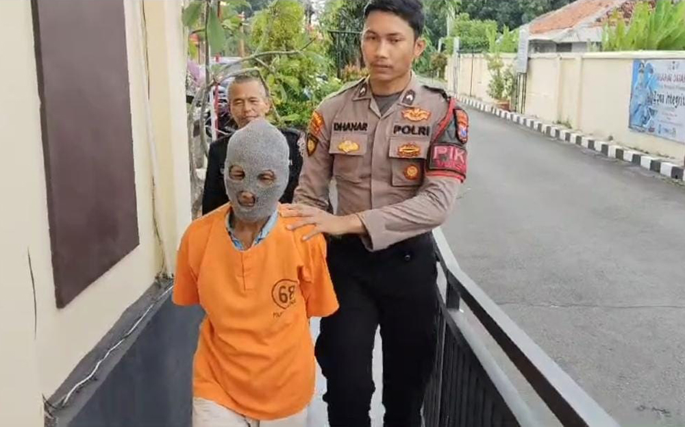DIKELER: Muasin, 64, warga Desa Curah Jeru, Kecamatan Panji, hendak dimasukkan ke sel tahanan Polres Situbondo, Senin (3/2).