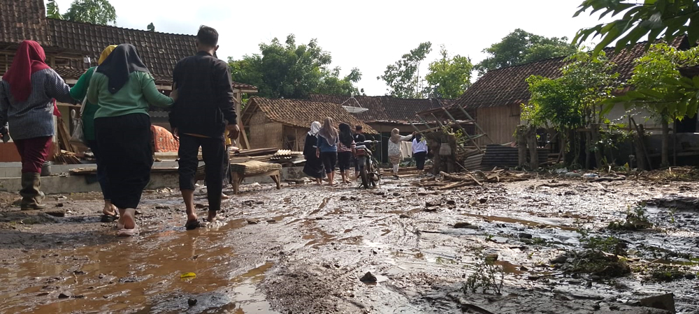 BEKAS BANJIR: Sejumlah warga melintas di jalan berlumpur di Desa Selowogo, Kecamatan Bungatan, Rabu (5/2).