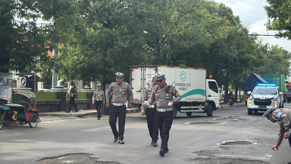 SIAP SIAGA: Anggota Satlantas Polres Situbondo meninjau ruas jalan berlobang, Kamis (13/2).