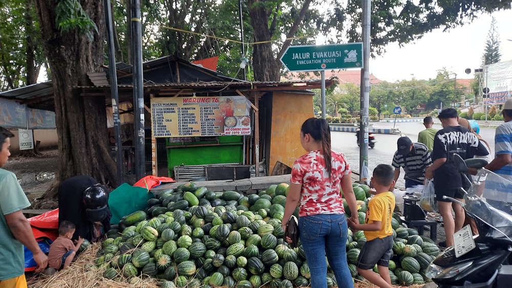 DISERBU PEMBELI: Pedagang buah blewah dan semangka di depan Kantor DPRD Situbondo diserbu pembeli, Senin (3/3).
