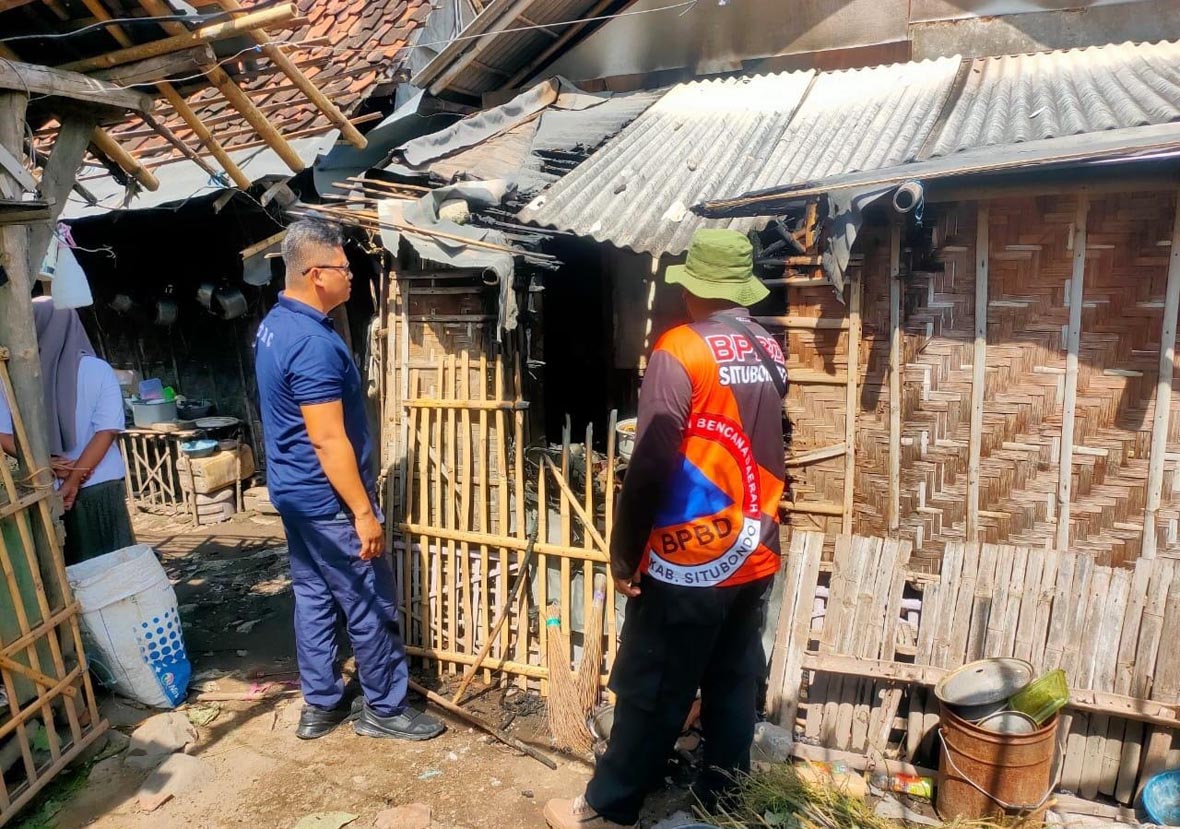 KEBAKARAN: Anggota BPBD Situbondo meninjau dapur terbakar milik Anik Purwasi, di Desa Curah Kalak, Kecamatan Jangkar, Jumat (7/3).