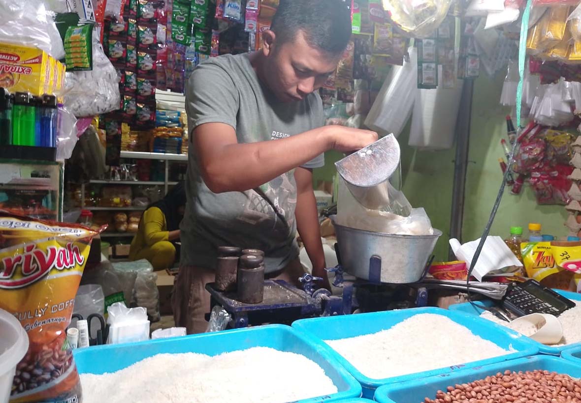 DITIMBANG: Seorang pedagang memasukkan beras ke dalam kantong plastik di Pasar Ardirejo, Kelurahan Mimbaan, Kecamatan Panji, Kamis (6/2).