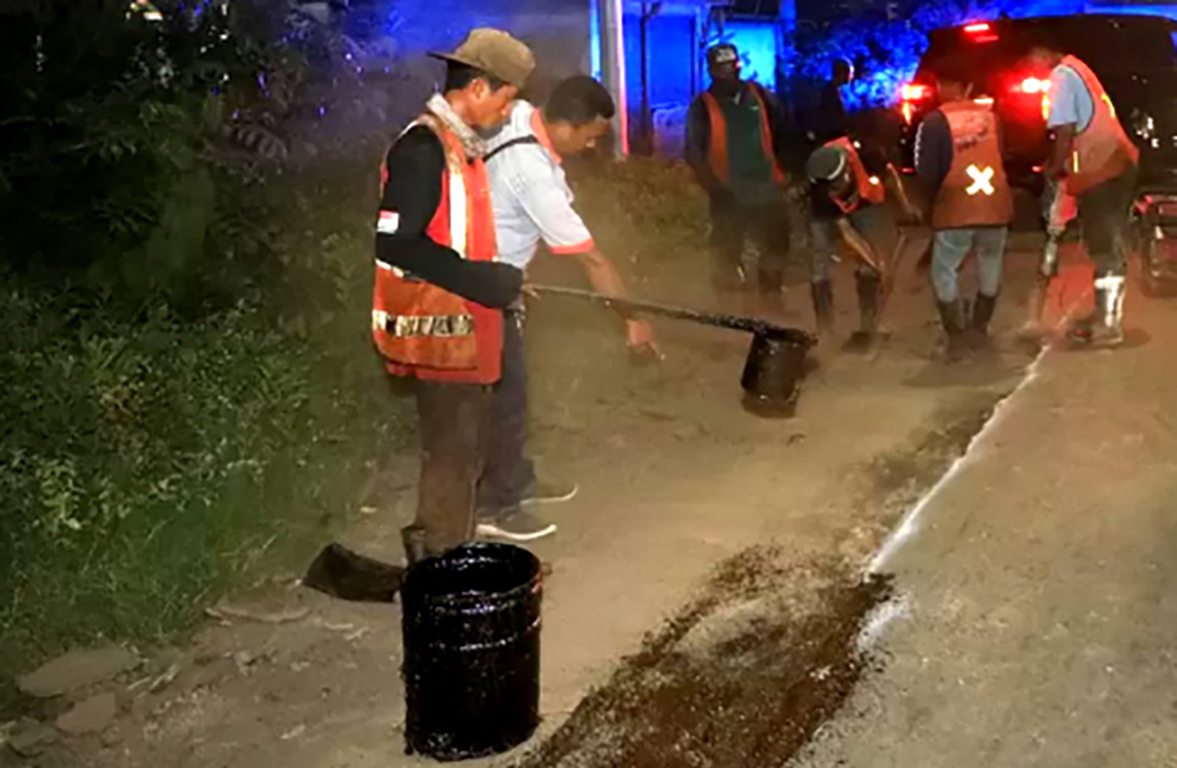 Petugas memberi lapisan aspal cair di jalur Pantura Jawa Timur di wilayah barat Situbondo