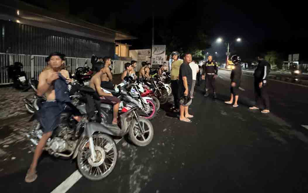 BALAP LIAR: Anggota Polres Situbondo mengamankan sejumlah pemuda yang menonton balapan liar, di Jalan Basuki Rahmad, Minggu dinihari (16/3).