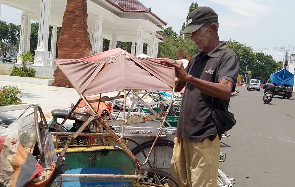 Sarjono masih menarik becak di seputar alun-alun Situbondo. (Iwan Feriyanto/Radar Situbondo)