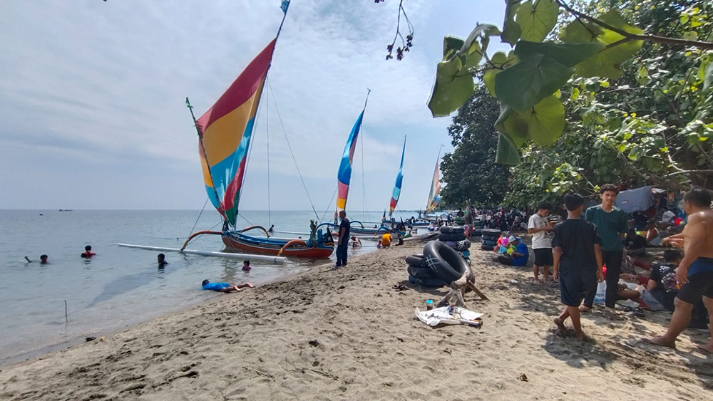 BERLIBUR: Wisatawan menikmati suasana di Pantai Pasir Putih, Kamis (3/4).