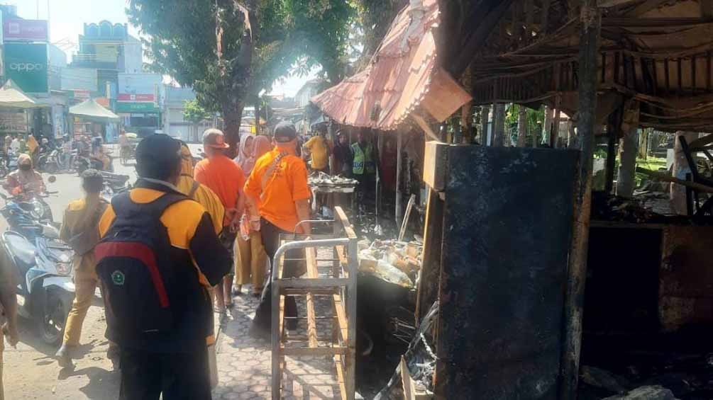 SUDAH PADAM: Petugas pemadam kebakaran berusaha memadamkan kobaran api yang membakar lapak PKL di pinggir trotoar Alun-alun Besuki, Selasa (8/4).
