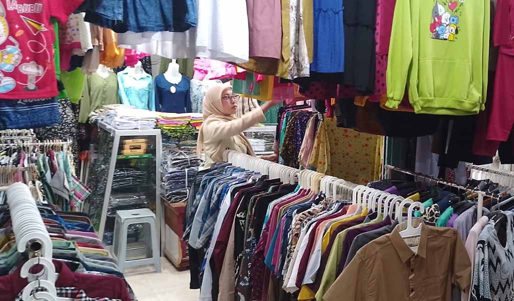 PILIH-PILIH: Salah satu warga mencari baju yang di lapak milik pedagang di pasar tingkat, Kelurahan Mimbaan, Kecamatan Panji, Selasa (8/4).