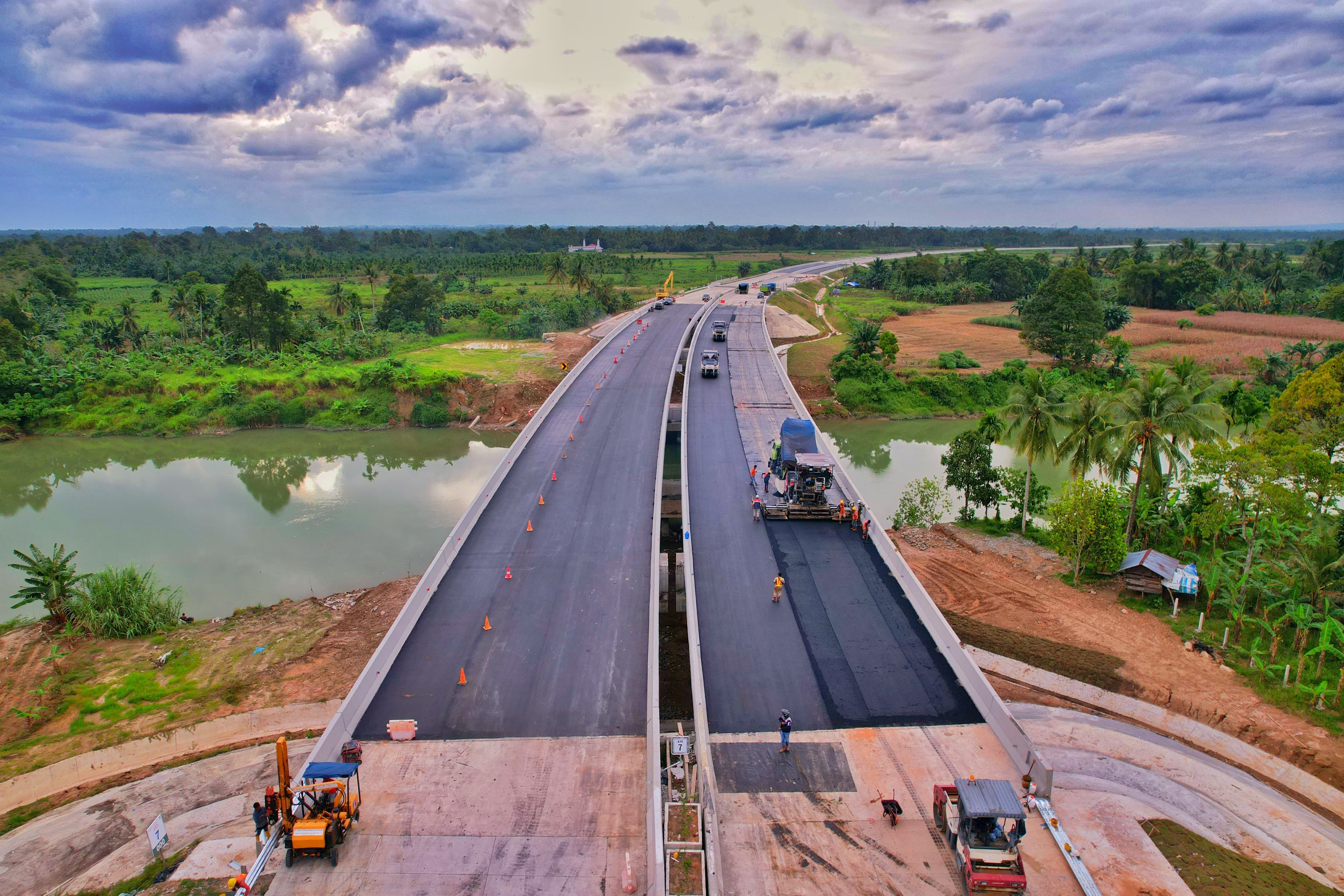 Alat berat memasang lapisan aspal hotmix di proyek jalan tol Padang Sicincin, Sumatera Barat.