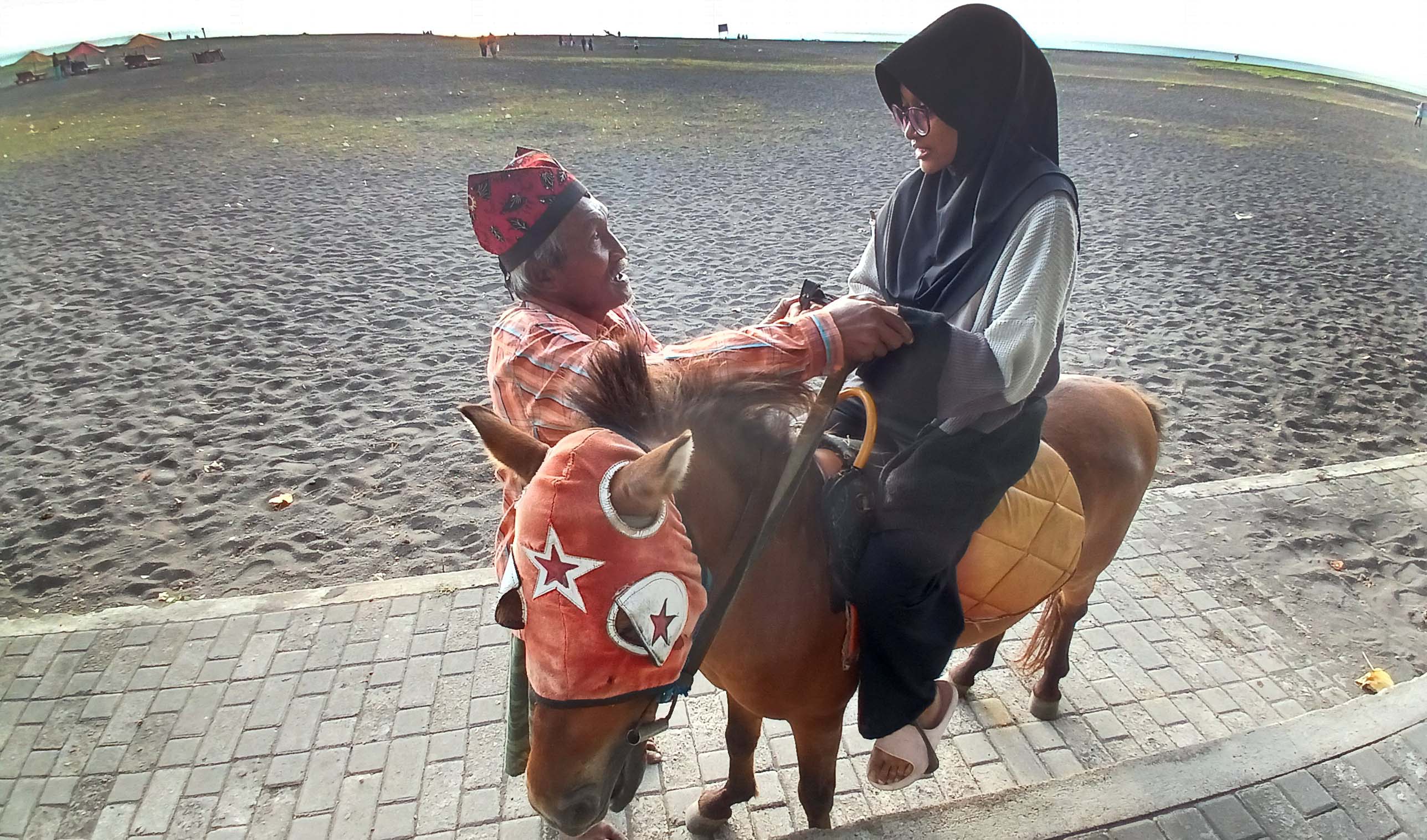 Remaja naik kuda di Pantai Boom Marina Banyuwangi.