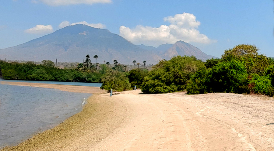 Pantai Sijile dengan hamparan pasir putih dan latar belakang Gunung Baluran di Situbondo.