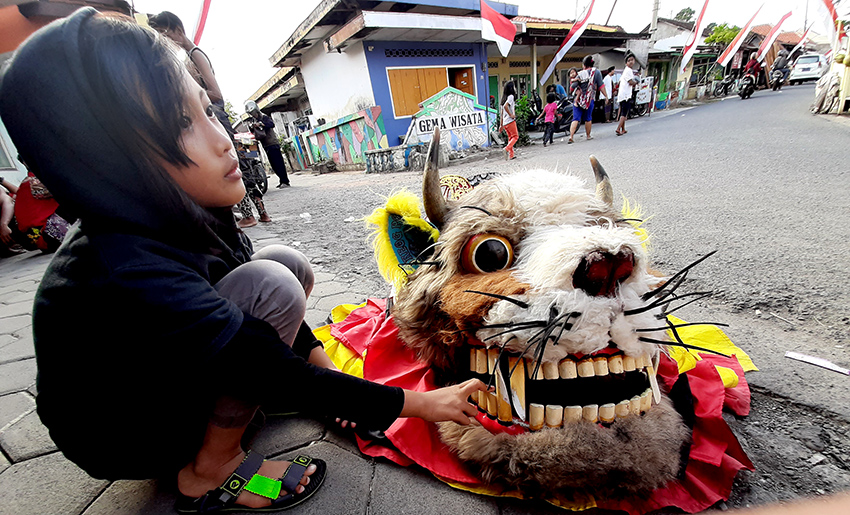 Anak-anak memegang kepala barong di Jalan Kalilo Banyuwangi.