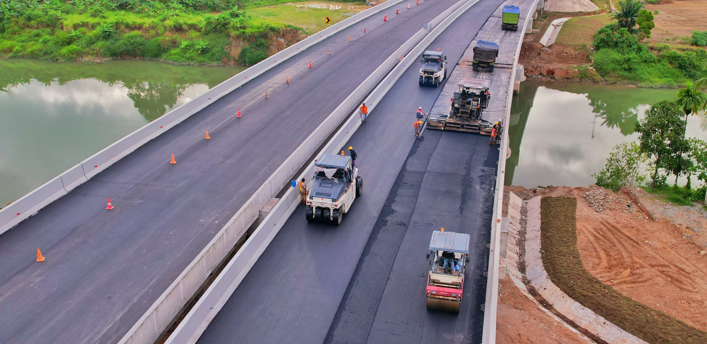 Beberapa slender menghaluskan dan memadatkan aspal hotmix di atas jembatan pada ruas jalan tol Padang di Sumatera Barat.