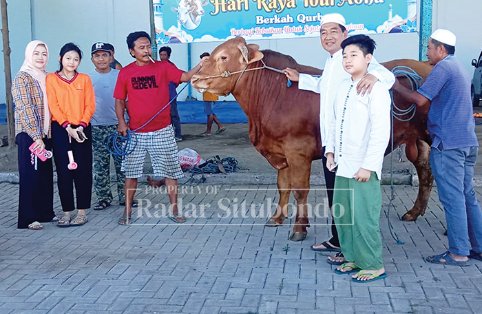 ABADIKAN MOMEN: H. Muhammad Mujiono (enam dari kiri) bersama keluarga besar, mengabadikan momen dengan sapi kurban,  di Gudang CV. Lintang Timur Jaya, Desa Awar-Awar, Kecamatan Asembagus, Sabtu Lalu.