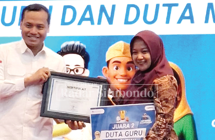 TERIMA HADIAH: Dina Amalia Firdausi, guru SMPN 3 Besuki meraih Juara 2 dalam pemilihan duta guru Cinta Bangga Paham Rupiah 2025.