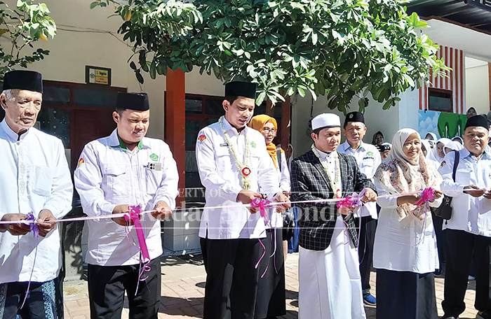 SEREMONIAL: Kepala Kemenag Situbondo, Mohammad Mudhoffar didampingi Pengasuh Ponpes Nurul Hikam, kiai Muhammad Yunus Zaini, memotong pita peresmian sekolah unggulan MA Nurul Hikam, kemarin (21/7).