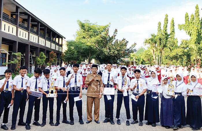 Kepala SMPN 3 Besuki Agus Sugianto memberikan penghargaan kepada siswa-siswi berprestasi pada ajang lomba FLS3N dan O2SN