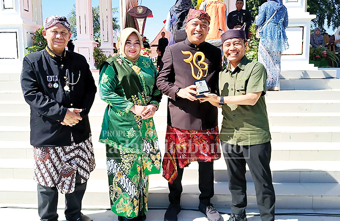 BERSINERGI: Direktur Jawa Pos Radar Banyuwangi Samsudin Adlawi (kanan) memberikan penghargaan kepada Bupati Situbondo Yusuf Rio Wahyu Prayogo, didampingi Wabup Ulfiah dan Sekda Wawan Setiawan.