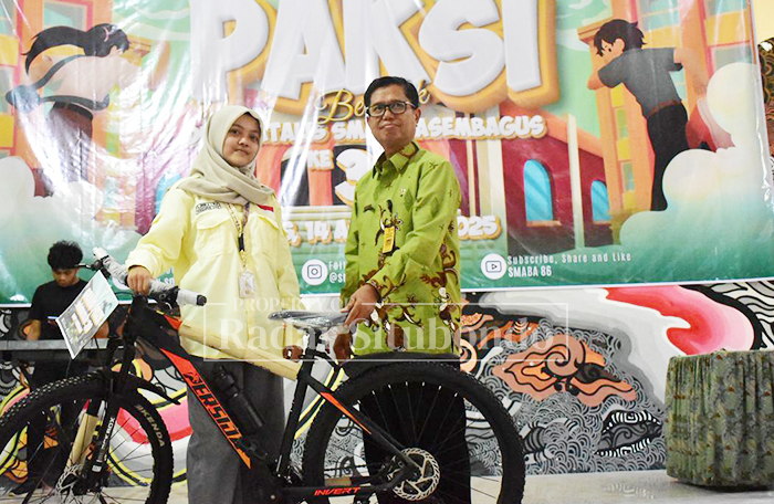 Kepala SMAN 1 Asembagus, Drs. Said Ripin Bukaryo, M.Si menyerahkan hadiah utama berupa sepada gunung kepada salah satu pemenang undian dalam acara jalan sehat pekan lalu.