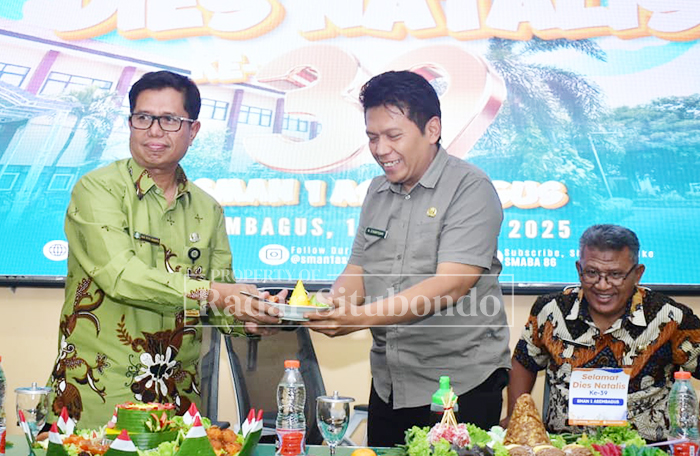 Kepala SMAN 1 Asembagus, Drs. Said Ripin Bukaryo, M.Si menyerahkan nasi tumpeng kepada Kasubag TU Cabdin Wilayah Bondowoso-Situbondo, Syarifuddin dalam acara Dies Natalis ke-39 SMAN 1 Asembagus